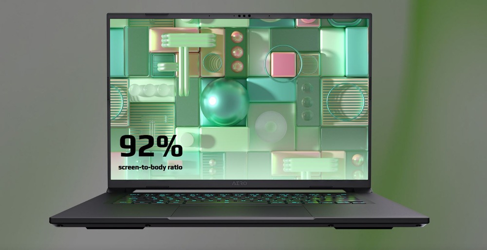 Notebook GIGABYTE AERO X16 1WH93CZC64AH černý/šedý Notebook s abstraktním geometrickým designem, se zelenými a růžovými tvary. Text zní „Poměr obrazovky k tělu 92 %“.