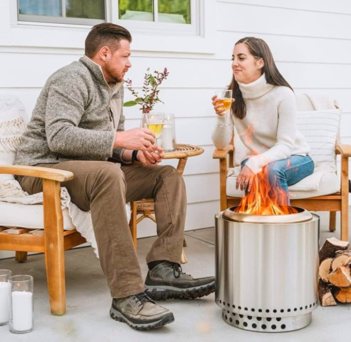 Dva lidé sedí na terase u ohniště Solo Stove Ranger + stand 2.0