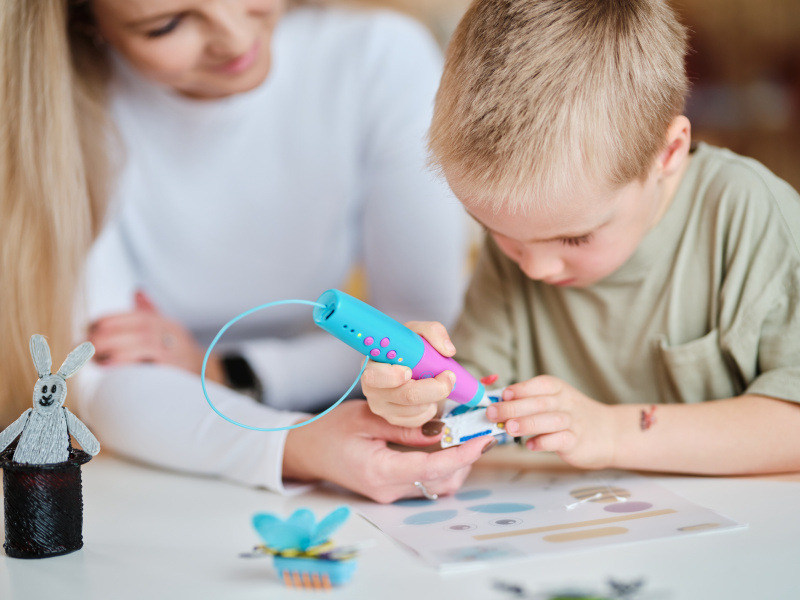 Náplň GoGEN Sada barevných PCL filamentů pro GOGBOB3DPERO, 36m Chlapec tvořící s modro-růžovým 3D perem GoGEN Bob a Bobek za asistence dospělé osoby.