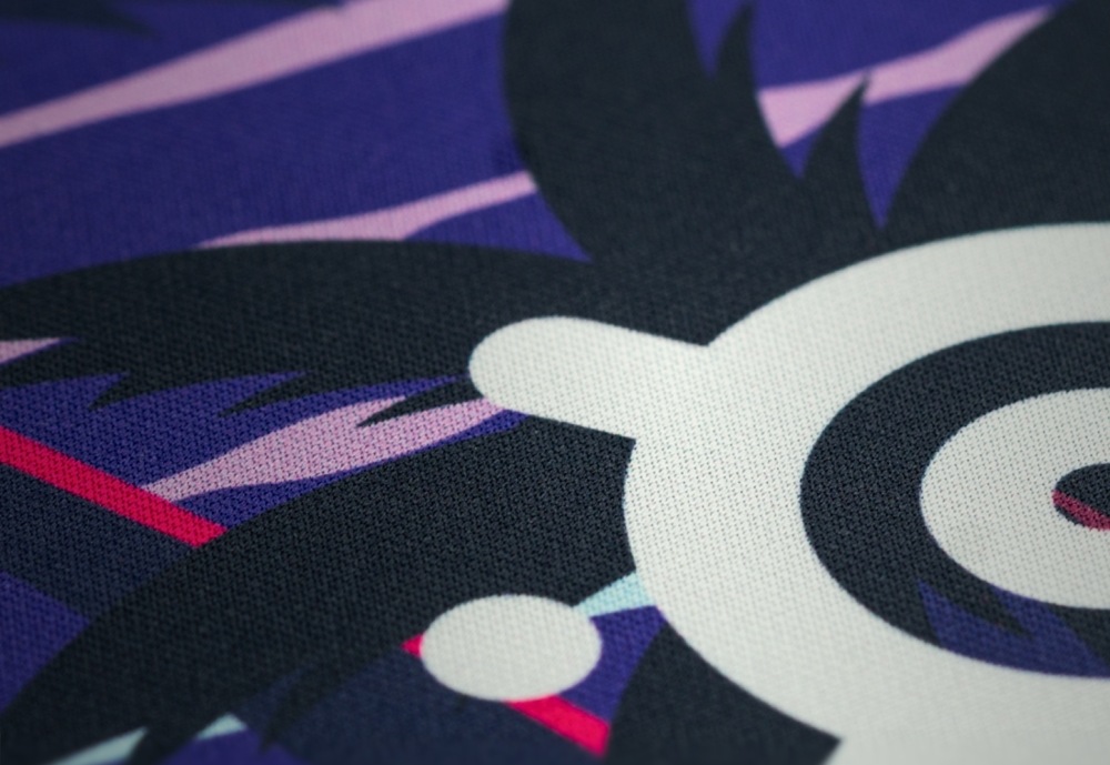 Podložka pod myš SteelSeries QcK Large, Neon Sunset fialová Detail textilního povrchu podložky QcK Neon Sunset s potiskem a logem SteelSeries