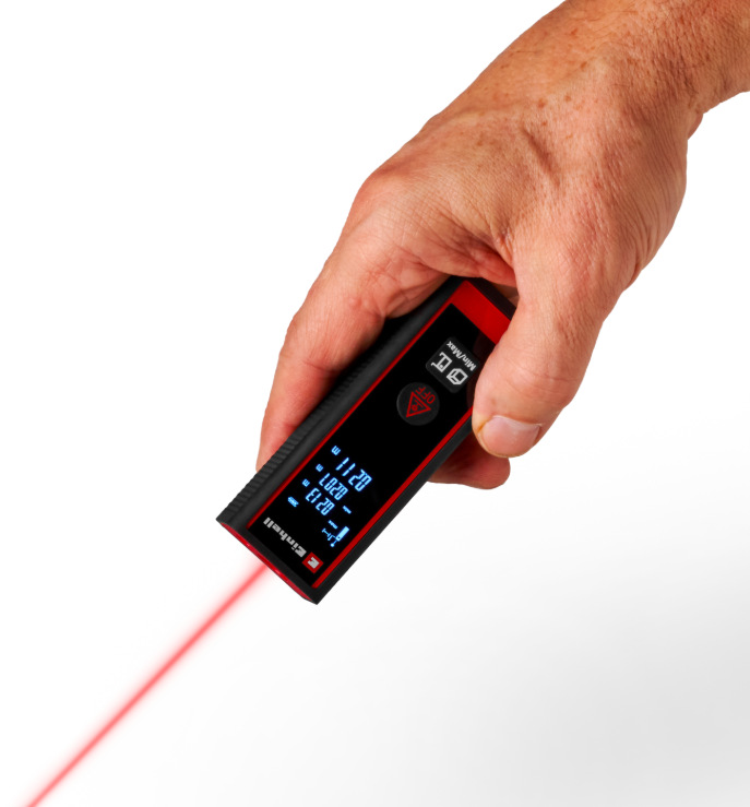 Ruka drží laserový dálkoměr Einhell Classic TC-LD 30 R při měření vzdálenosti červeným laserem