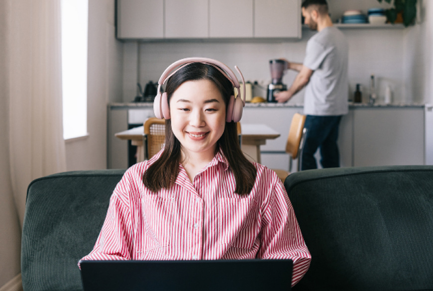 Uživatelka s headsetem Logitech Zone Wireless 2 ES při práci na notebooku doma