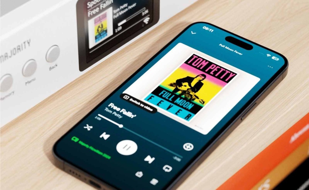 Internetový radiopřijímač s DAB+ Majority Fitzwilliam 2 stříbrný Mobilní telefon s aplikací Spotify vedle internetového rádia Majority Fitzwilliam.