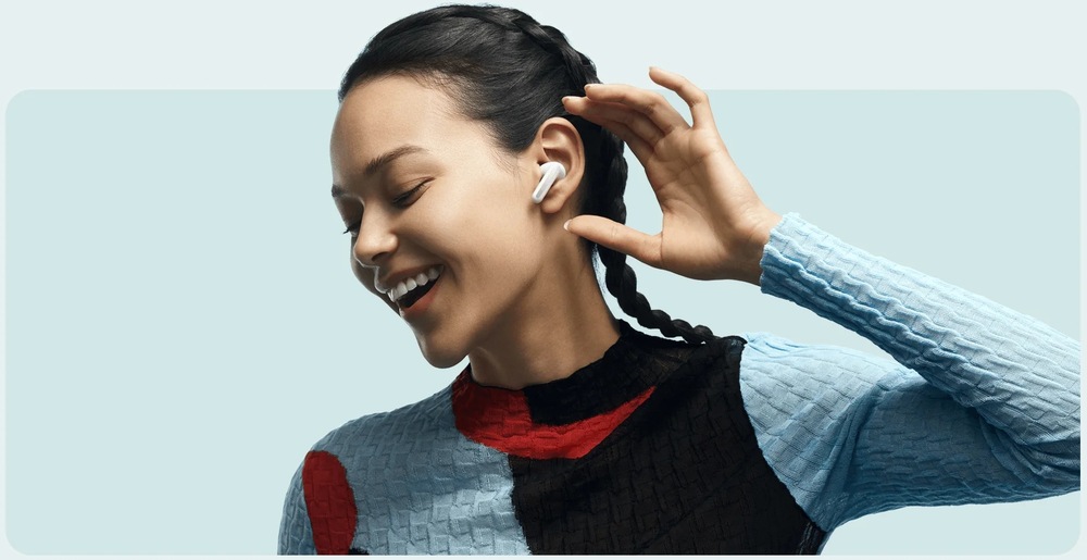 Sluchátka Xiaomi Buds 6 Ceramic White bílá Smějící se žena se sluchátkem Xiaomi Buds 6 v uchu