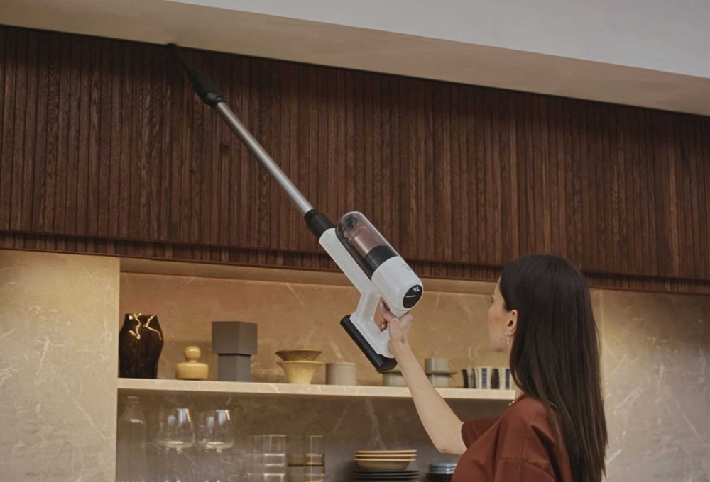 Žena vysává s vysavačem Electrolux pod stropem. 