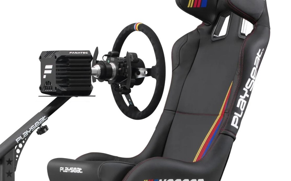 Elegantní závodní kokpit s bílým nápisem Playseat a barvami NASCAR po stranách s připojeným závodním volantem pro pohlcující zážitek z hraní závodních simulátorů.