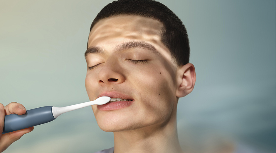 Muž si čistí zuby kartáčkem sonicare