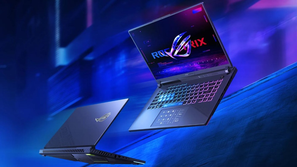 Herní notebook viděný z přední a zadní strany se vznáší ve futuristickém prostředí osvětleném modrým světlem.