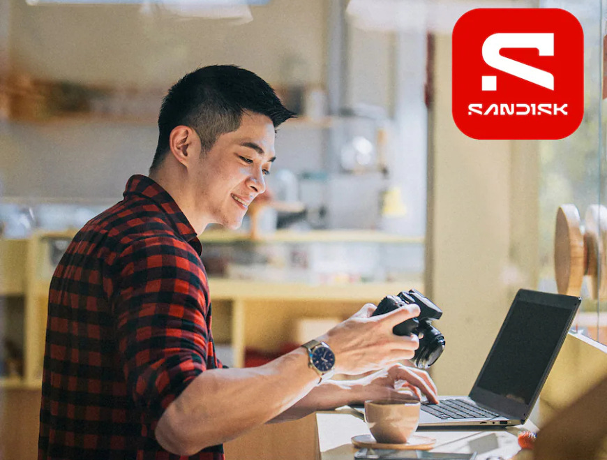 Fotograf přenáší snímky z fotoaparátu do notebooku pomocí paměťové karty SanDisk Ultra Plus
