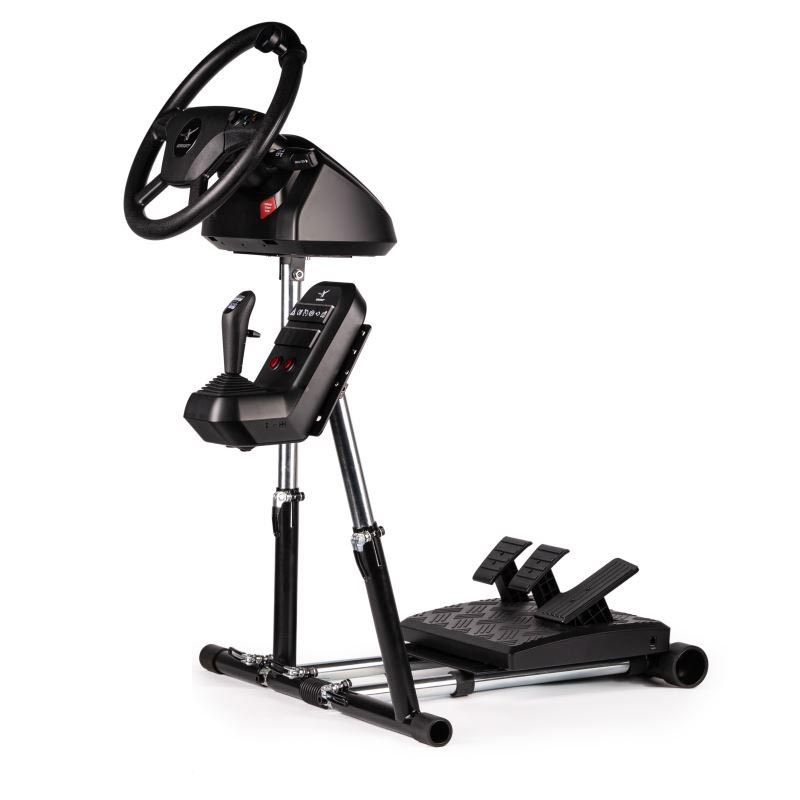 Záběr na herní volant, řadicí páku a sadu pedálů, které jsou připevněné na stojanu Wheel Stand Pro Farm Truck V3 v černé barvě se stříbrnými kovovými akcenty.