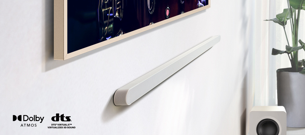 Samsung HW-S801D je připevněn na zdi pod televizí Samsung Frame, v levém spodním rohu jsou loga Dolby Atmos a dts