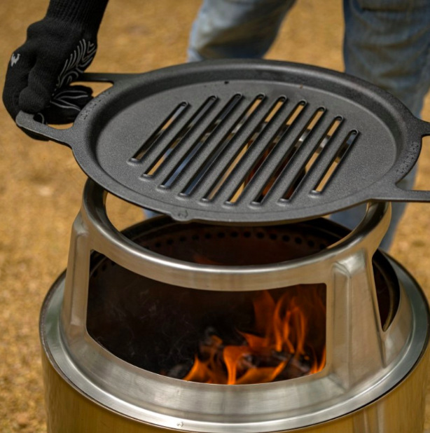 Litinový grilovací rošt Solo Stove Ranger umístěný na ohništi s viditelným plamenem