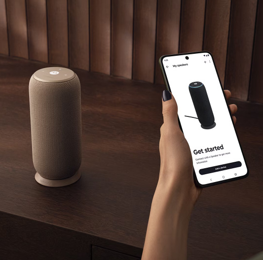 Žena drží v ruce smartphone vedle reproduktoru Motorola Moto Sound Flow