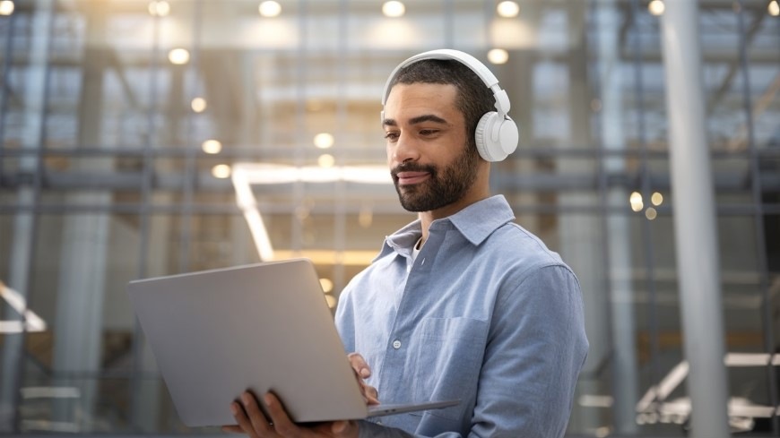 Sluchátka Philips TAH4500WT/00 bílá Muž s notebookem v ruce má hlavě sluchátka Philips TAH4500