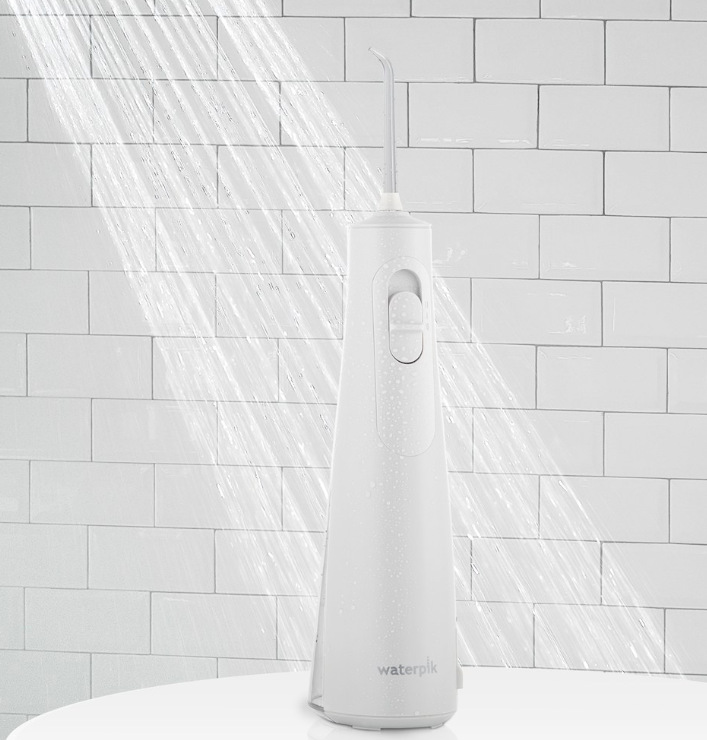 Vodotěsná ústní sprcha Waterpik WF21EU umístěná pod proudem vody ve sprchovém koutě