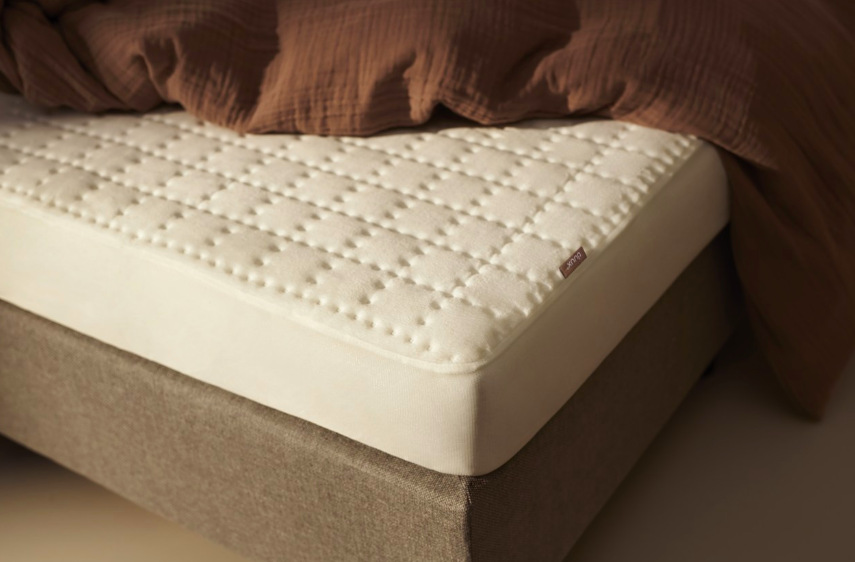 Detail fleecového povrchu a uchycení vyhřívací podložky Duux Snooze na matraci
