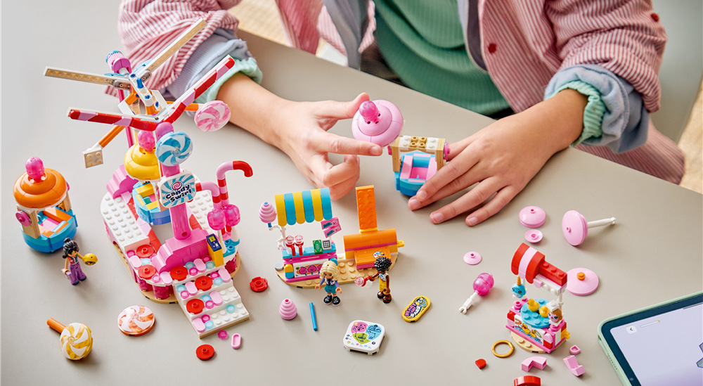 Stavebnice LEGO® Friends 42700 Kolotoč se sladkostmi a cupcaky Otáčející se kolotoč a stánek s cukrovou vatou přenesou Novu, Zaca a Liann na veselou pouť.