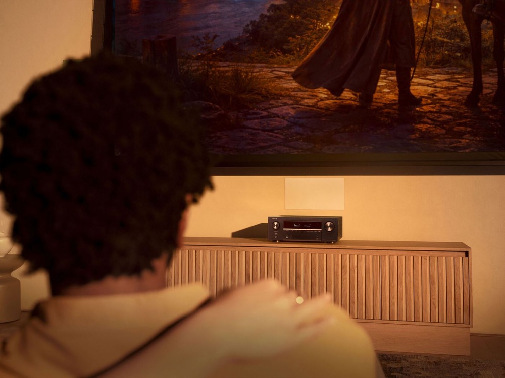 Muž sleduje film s receiverem Denon AVC-X3900H