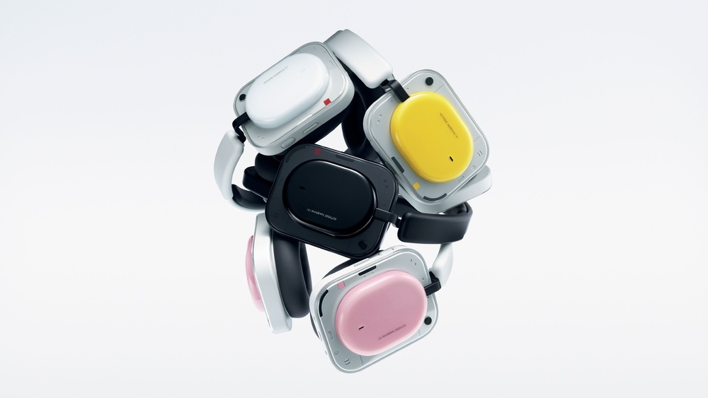 Sluchátka Nothing Headphone (a) B186 žlutá Bezdrátová sluchátka Nothing v různých barvách, včetně černé, bílé, žluté a růžové, uspořádaných ve vyvážené dynamické formaci.