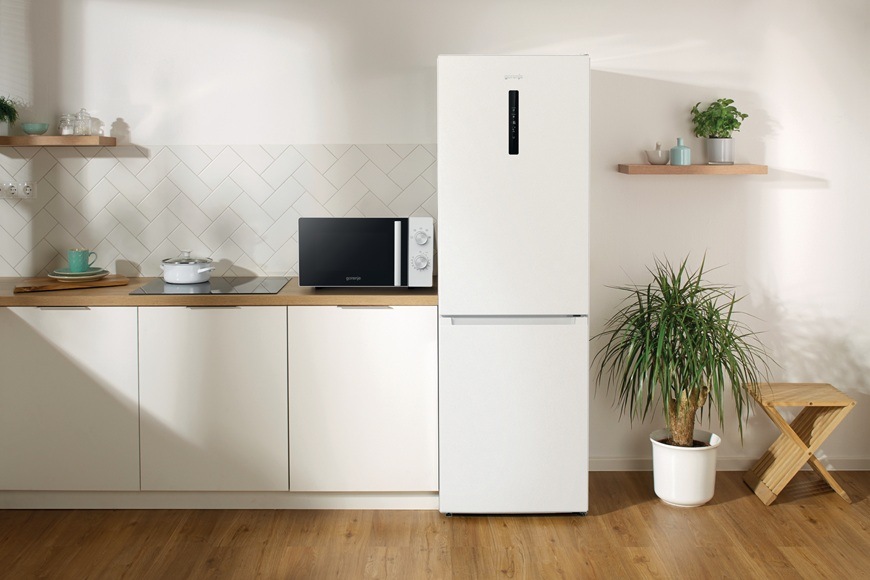 Volně stojící mikrovlnná trouba Gorenje MO20E1WI5 je položená na lince v moderní kuchyni.