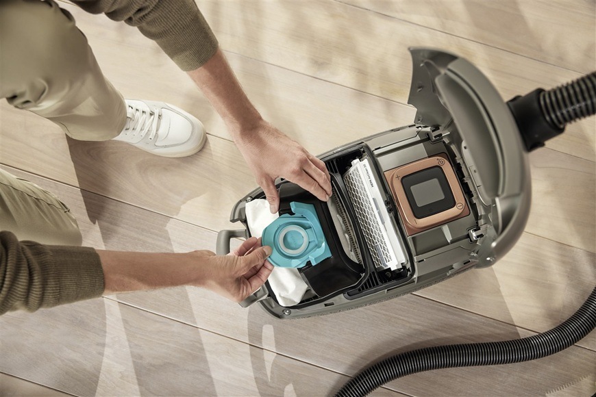 Sáčky do vysavače Miele TU XL HyClean Pure (8 ks) Muž vyměňuje ve vysavači Miele sáček