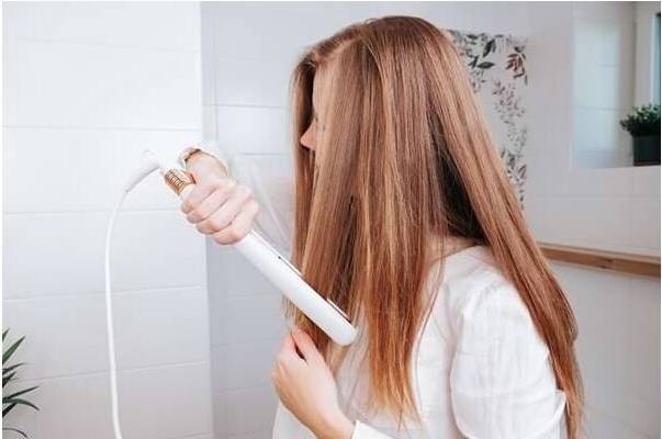 Žena si v koupelně vyrovnává dlouhé vlasy pomocí žehličky Concept VZ2110 Glam Style