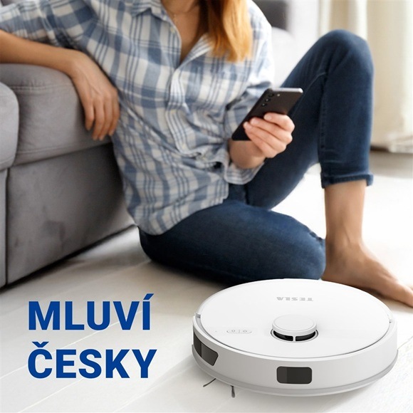 Žena ovládající robotický vysavač pomocí aplikace.