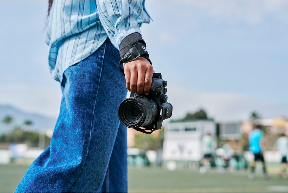 Fotografka drží kompaktní fotoaparát Sony RX10 V připravený k fotografování sportovních akcí
