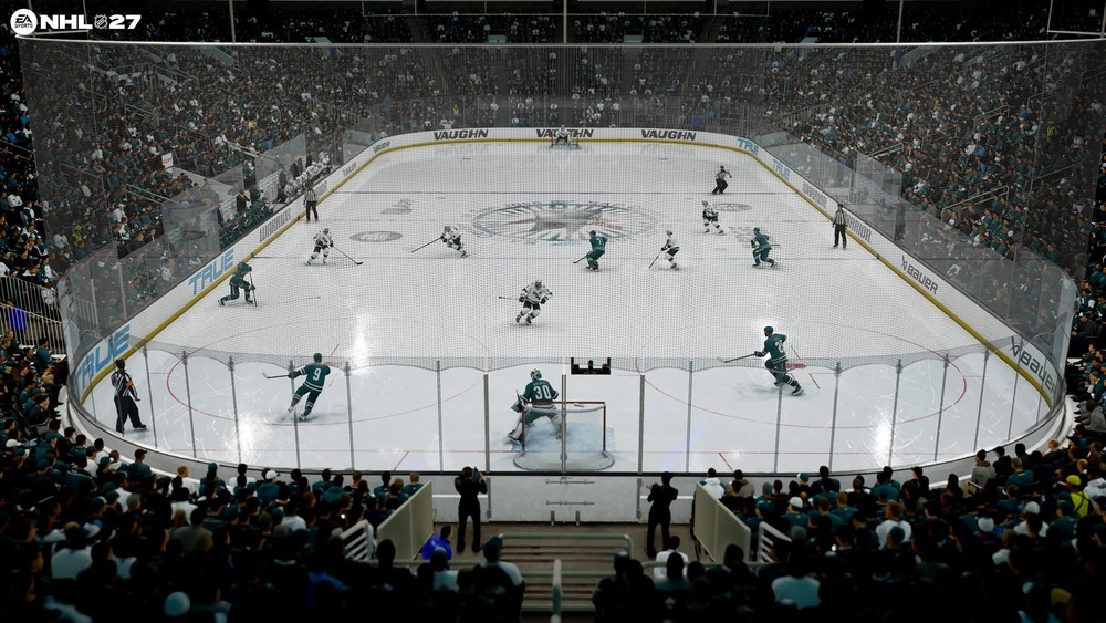 Hokejový zápas v NHL 27 v zaplněné aréně, kde týmy v tyrkysově bílých dresech bojují poblíž branky, zatímco brankář stráží síť.