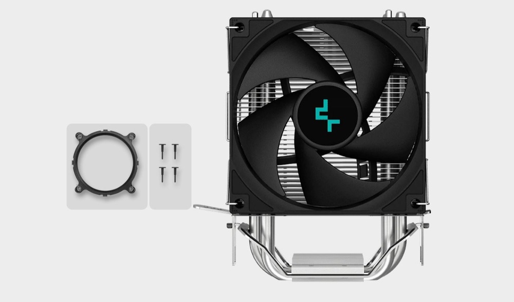 Vidíme černý chladič CPU s velkým ventilátorem a kovovými tepelnými trubicemi. Vlevo je na světle šedém pozadí montážní kroužek a čtyři připevňovací kolíčky.