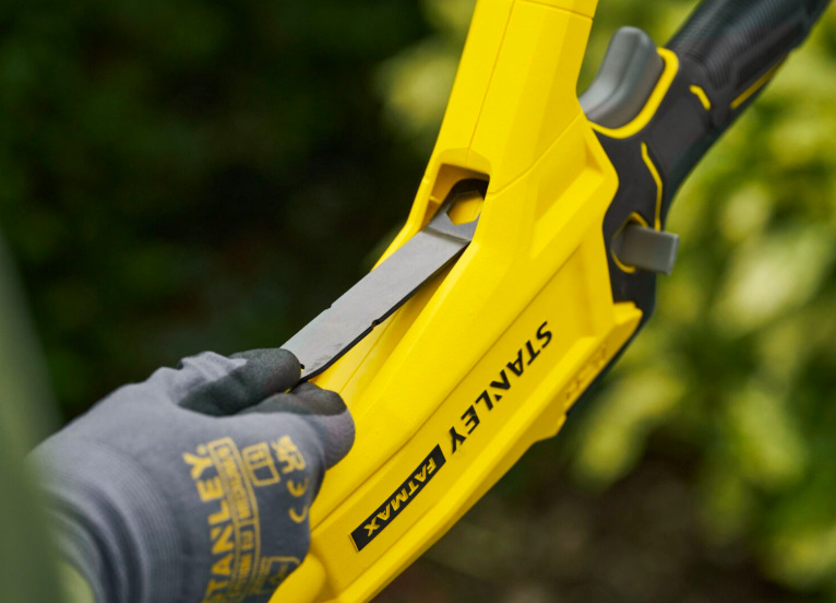 Detail integrovaného držáku klíče odvětvovače Stanley FatMax SFMCPS720B-XJ pro nastavení řetězu