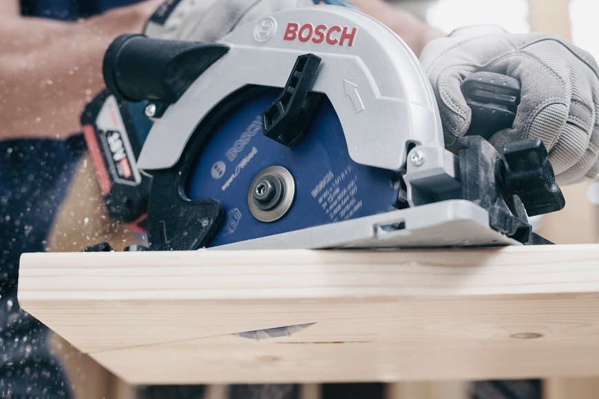 Muž řeže dřevěnou desku s pilovým kotoučem Bosch PRO 2.608.644.508.