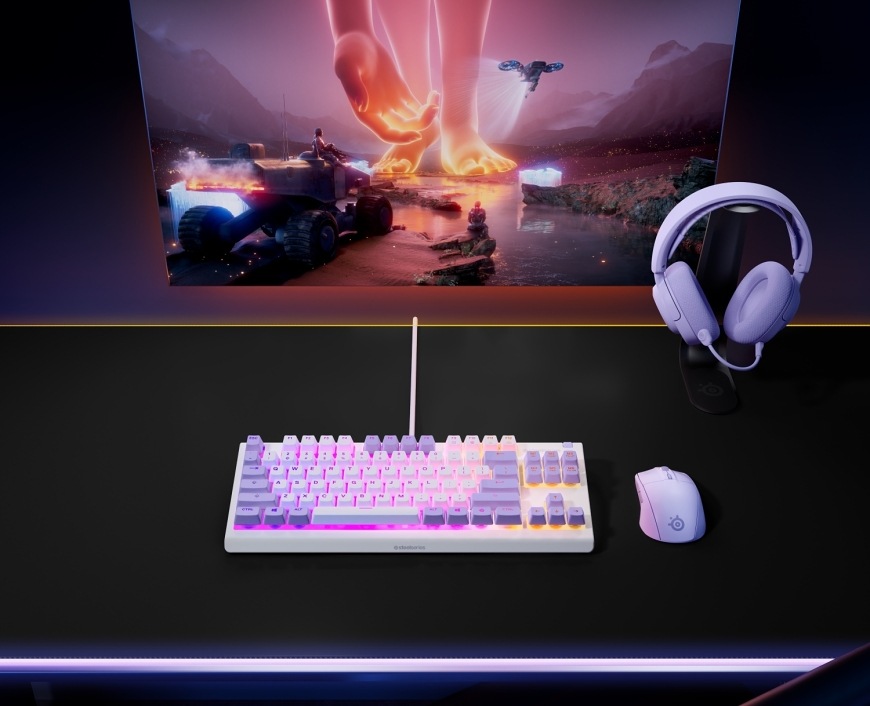 Klávesnice SteelSeries Apex 3 TKL Amethyst, US layout bílá/fialová Podsvícená herní klávesnice na stole s monitorem a headsetem