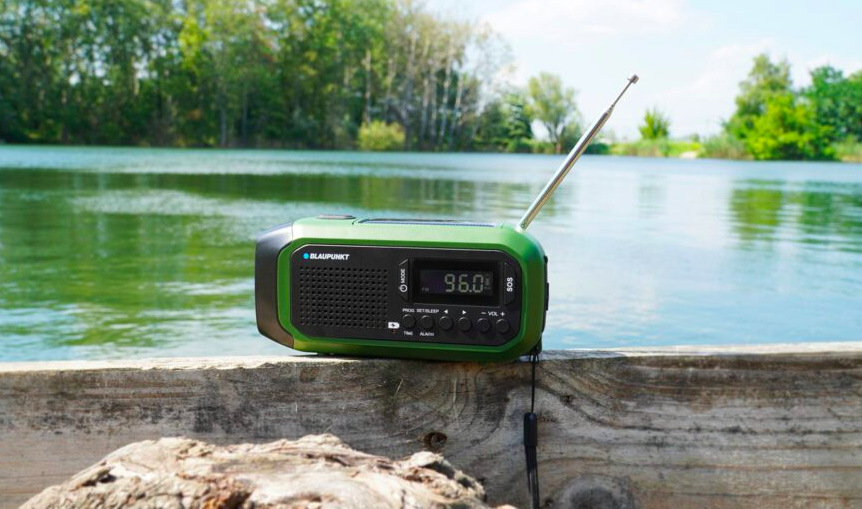 Radiopřijímač u jezera při venkovním poslechu rádia během odpočinku v přírodě