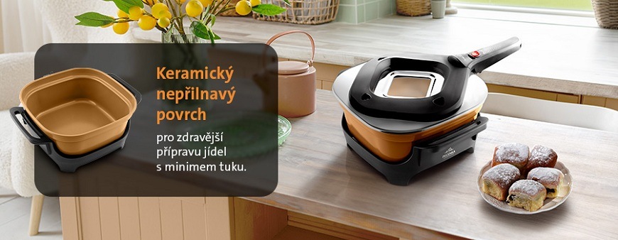 Elektrický pečicí hrnec ETA PEČENKA s béžovým keramickým nepřilnavým povrchem pro zdravější vaření s minimem tuku postavený na jídelním stole vedle Honzových buchet