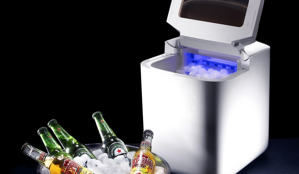 Výrobník ledu Catler IM 810 Ice Maker bílý Otevřený výrobník ledu Catler IM 810 Ice Maker, v zásobníku je led, před výrobníkem leží nádoba s chlazenými lahvemi piva