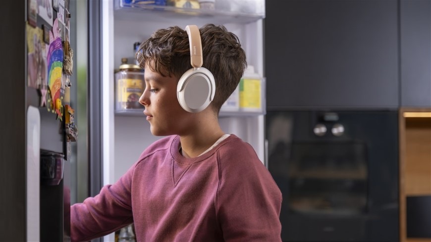 Sluchátka Philips Dětská TAK5500AL béžová Chlapec se sluchátky Philips TAK5500AL sahá do ledničky pro jídlo