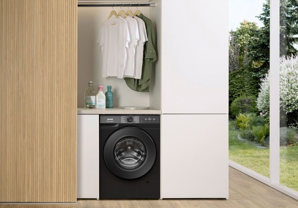 Pračka Gorenje G400 WG484A31B UltraClean černá pračka Gorenje WG484A31B UltraClean mezi dvěma velkymi skříněmi, nad pračkou visi trička na raminku