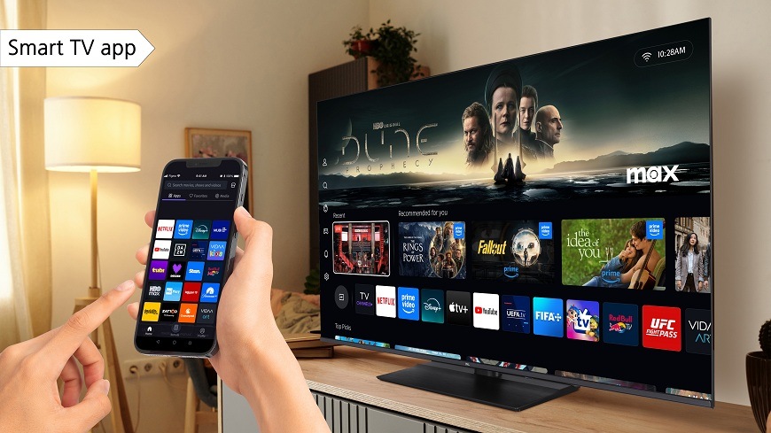 Televize JVC na televizním stolku v obývacím pokoji, která je ovládána pomocí mobilního telefonu