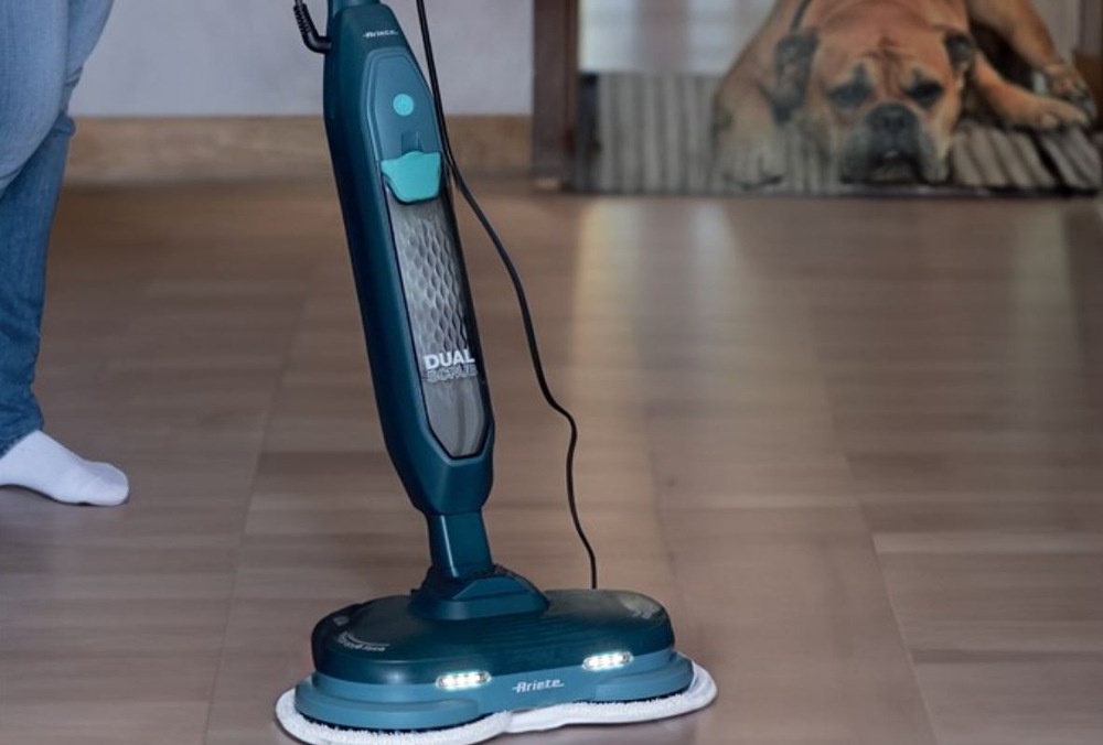 Parní mop Ariete ART 4178/BL tmavě modrý Mopovaní dřevěné podlahy parním čističem Ariete ART 4178/BL. V pozadí leží pes na koberečku.