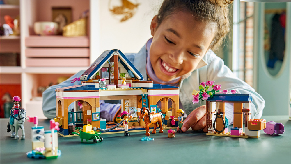 Stavebnice LEGO® Friends 42688 Koňská stáj a jezdecká akademie Liann, Aliya a Cindy trénují parkur, zdolávají dvě překážky a mohou si uspořádat vlastní jezdecké závody.