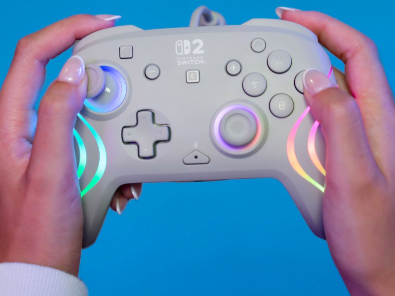 Hráčka ovládá šedý gamepad Turtle Beach Afterglow Wave s aktivním RGB podsvícením