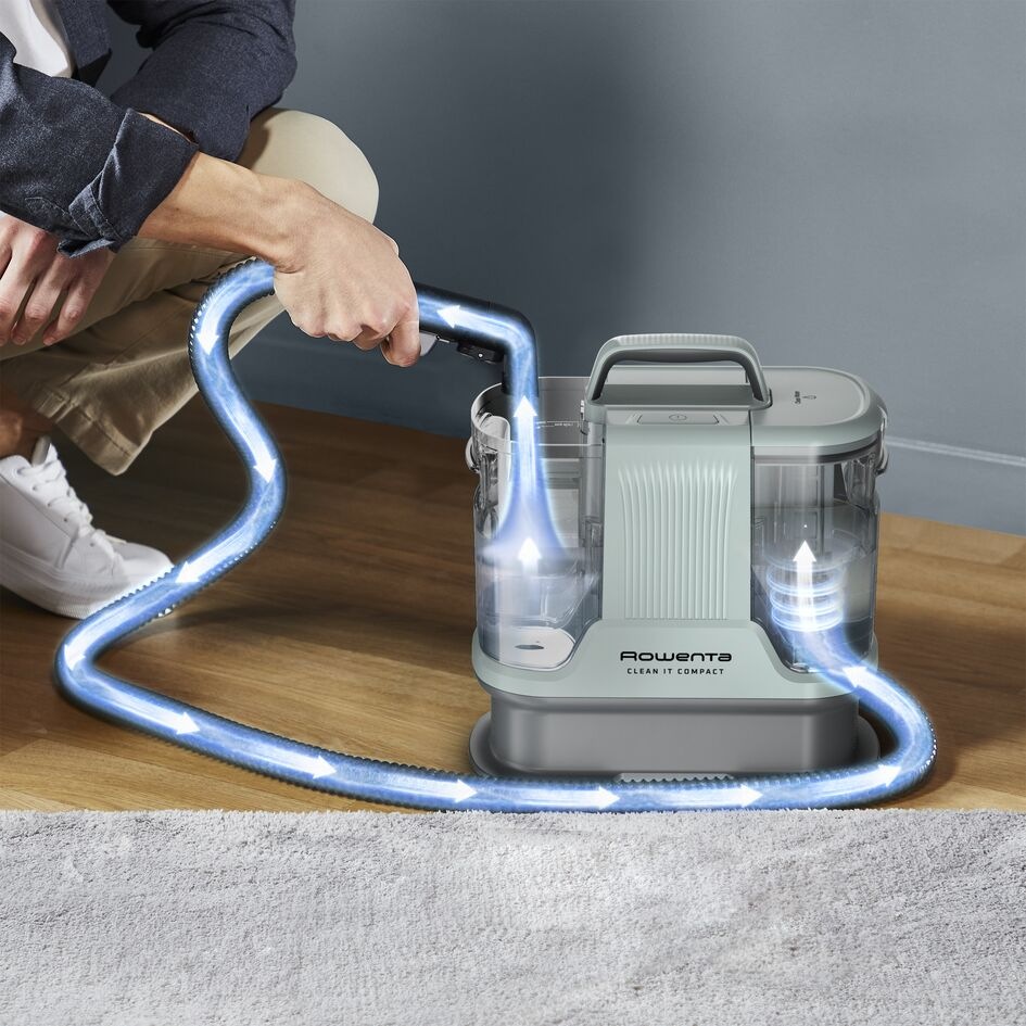 Čistič skvrn Rowenta IN3020F0 Clean It Compact Animal zelený Muž drží tepovač Rowenta IN3020F0 Clean It Compact Animal který provádí samočištění