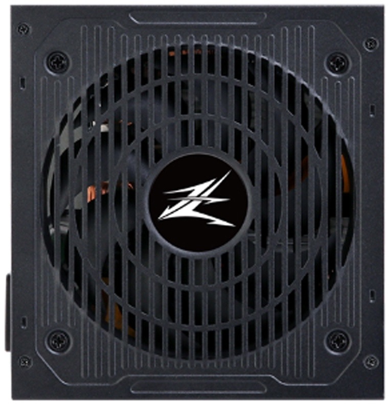 Zdroj Zalman MegaMax ZM600-TXII 600W černý Na fotce je čelní pohled na napájecí zdroj Zalman. Většinu plochy zabírá velký černý ventilátor krytý pevnou mřížkou s logem Zalman uprostřed. Tělo zdroje je tmavé, hranaté a v rozích jsou vidět šrouby. Jde o technický detail chladicí části zdroje.