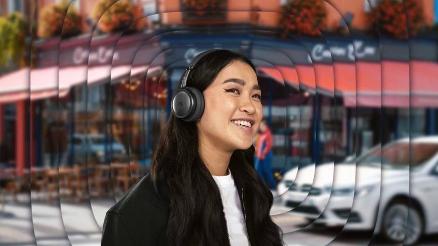 Žena se sluchátky JBL Live 680NC je obklopena zvukovými vlnami