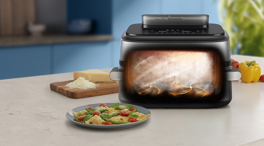 Fritéza horkovzdušná Philips Airfryer Dual Basket s párou 9,5 l NA565/02 černá/stříbrná Horkovzdušná fritéza Philips NA565/02 s grafickým znázorněním proudění horkého vzduchu a páry uvnitř během přípravy jídla. Na kuchyňské lince vedle spotřebiče je talíř s těstovinami, prkénko se sýrem a čerstvá zelenina.