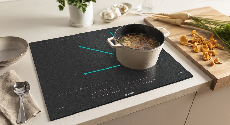 Indukční varná deska Gorenje G600 GI6442MSCWF InfiniteMatt černá Hrnec se přesunul z jedne varme zony desky gorenje na druhou a zustalo zachovano nastaveni. Jsou v obrazku videt šipky, odkud kam. Vedle desky je pripravena zelenina.