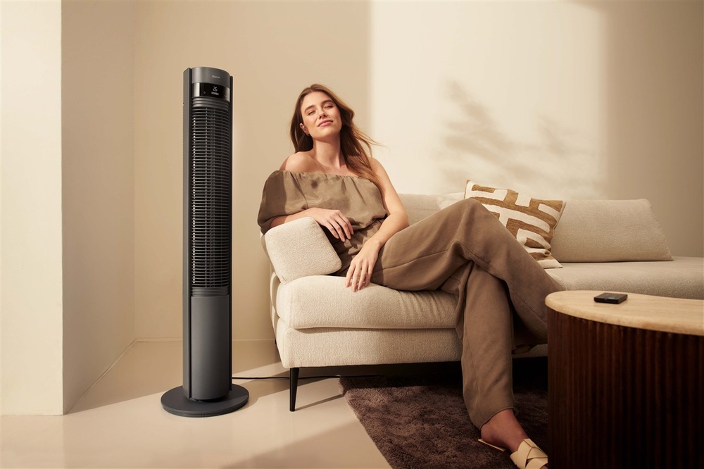 designový ventilátor Duux Elevate Tower Smart v interiéru vedle pohovky