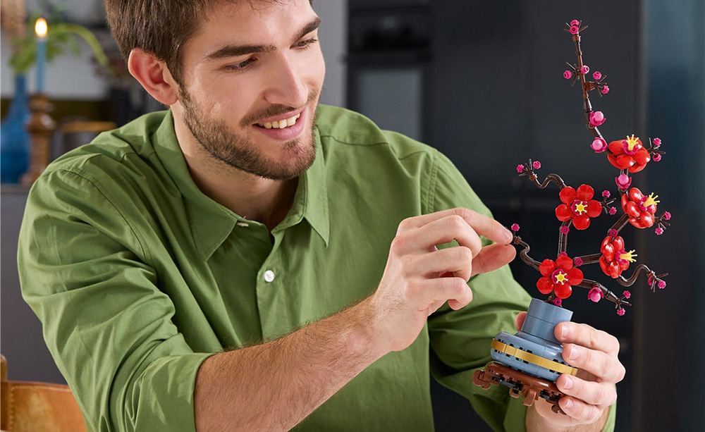 Stavebnice LEGO® Botanicals 10369 Meruňka japonská Pastelově modrý květináč se zlatým páskem a dřevěným podstavcem vytváří působivé dekorativní aranžmá.
