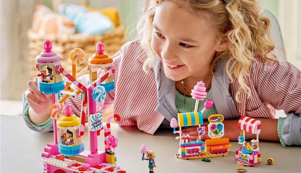 Stavebnice LEGO® Friends 42700 Kolotoč se sladkostmi a cupcaky Za úspěšné házení kroužků mohou postavičky vyhrát plyšovou koblihu, narvala nebo včelu.
